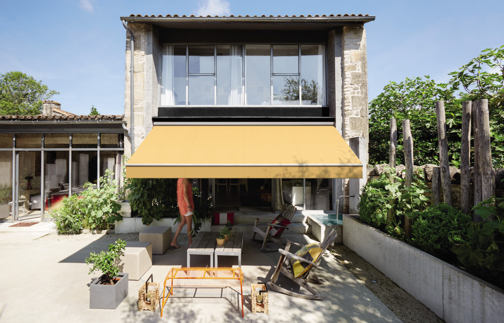 toile de store banne jaune sur façade de villa