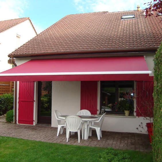 store banne classic rouge devant un pavillon aux volets rouges