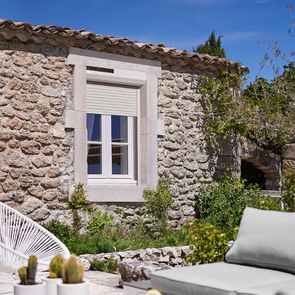 Volet roulant solaire sur une façade de maison en pierre